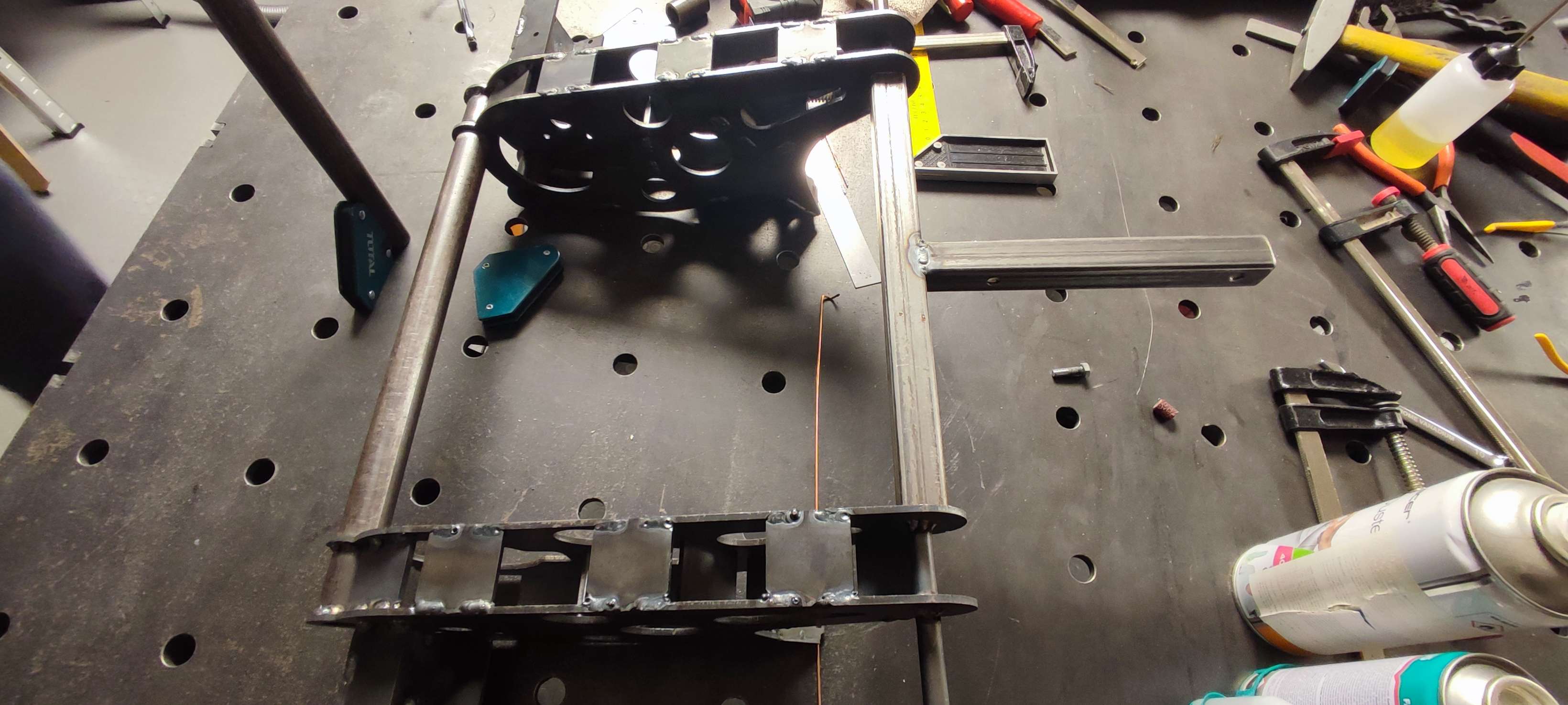 Partially welded frame sections clamped in a welding jig